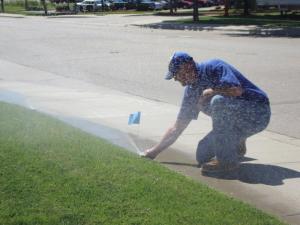 A Lincoln Sprinkler Repair tech marks an optimized pop up head